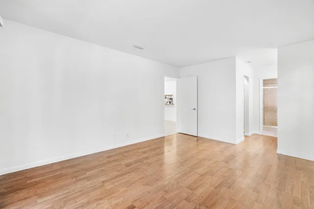 a view of an empty room with wooden floor
