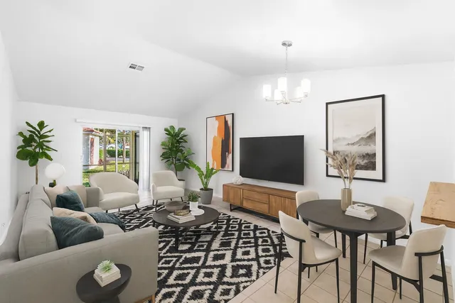 a living room with furniture a chandelier and a flat screen tv