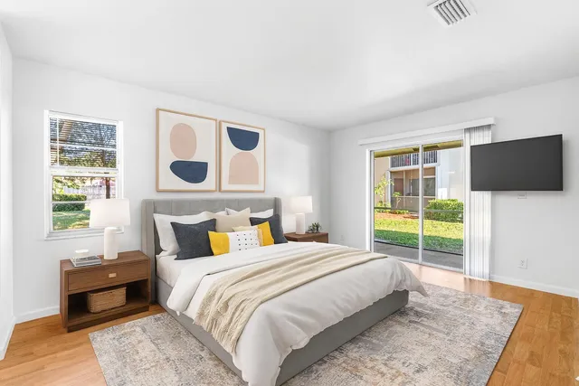 a bedroom with a bed and a flat tv screen next to a window