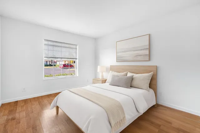 a bedroom with a bed and a painting on the wall