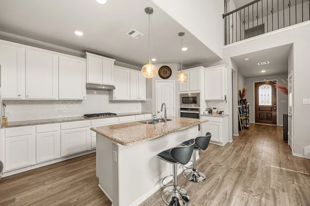 a kitchen with stainless steel appliances granite countertop a sink stove and refrigerator