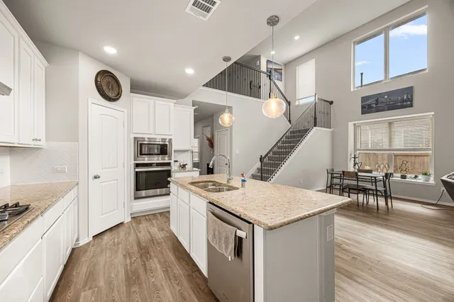 a kitchen with granite countertop a white stove top oven and cabinets