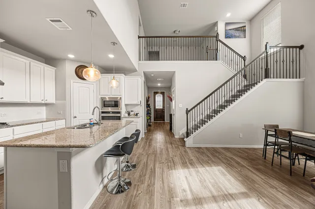 a view of entryway and kitchen with wooden floor