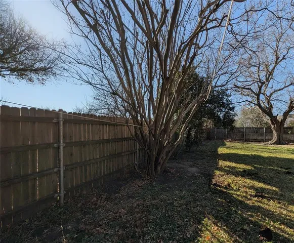 a view of a backyard with wooden fence