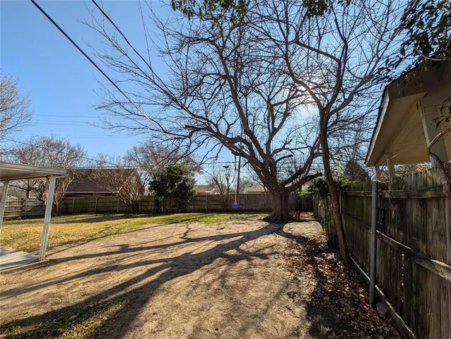 a view of a yard with wooden fence