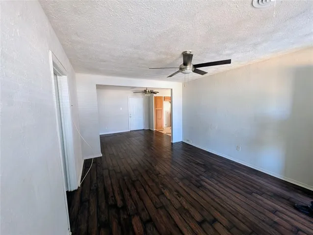 a view of a hallway with wooden floor and a ceiling fan