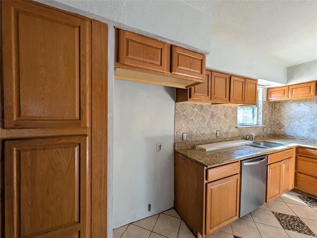 a kitchen with stainless steel appliances granite countertop a sink and a refrigerator