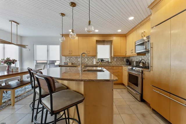 a kitchen with a dining table chairs and white appliances