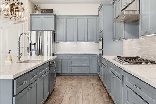 a kitchen with kitchen island granite countertop a sink stove and refrigerator