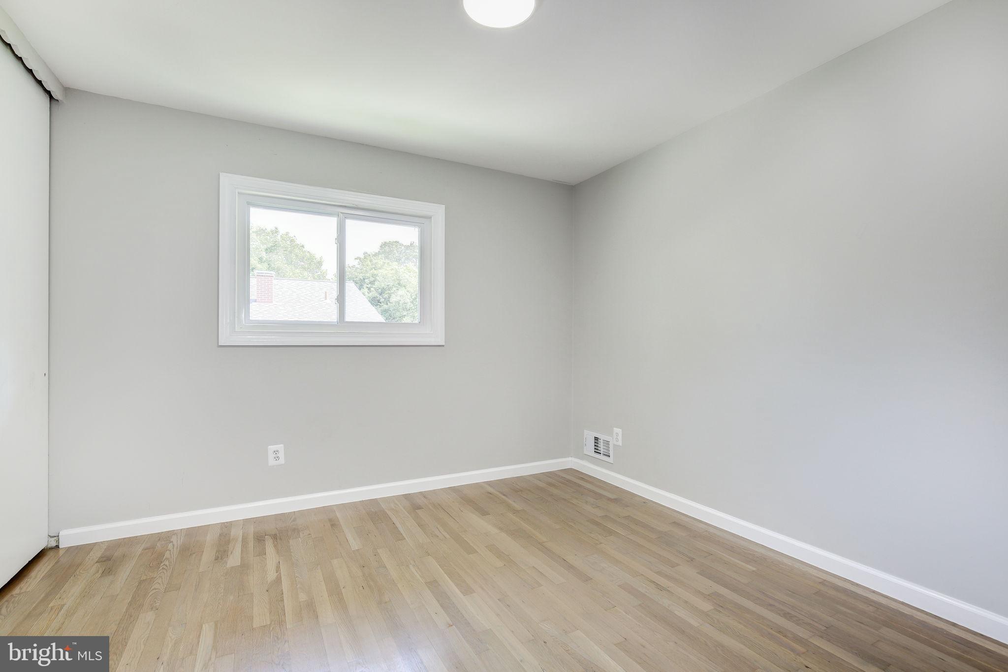 11830 Charles Road Silver Spring, MD 20906 - Photo 16 of 54 an empty room with wooden floor and windows