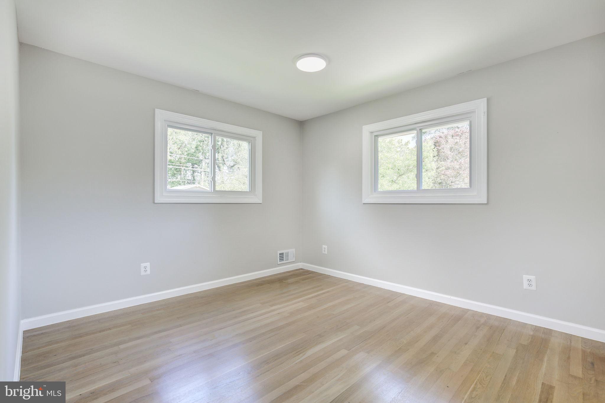 11830 Charles Road Silver Spring, MD 20906 - Photo 20 of 54 an empty room with wooden floor and windows