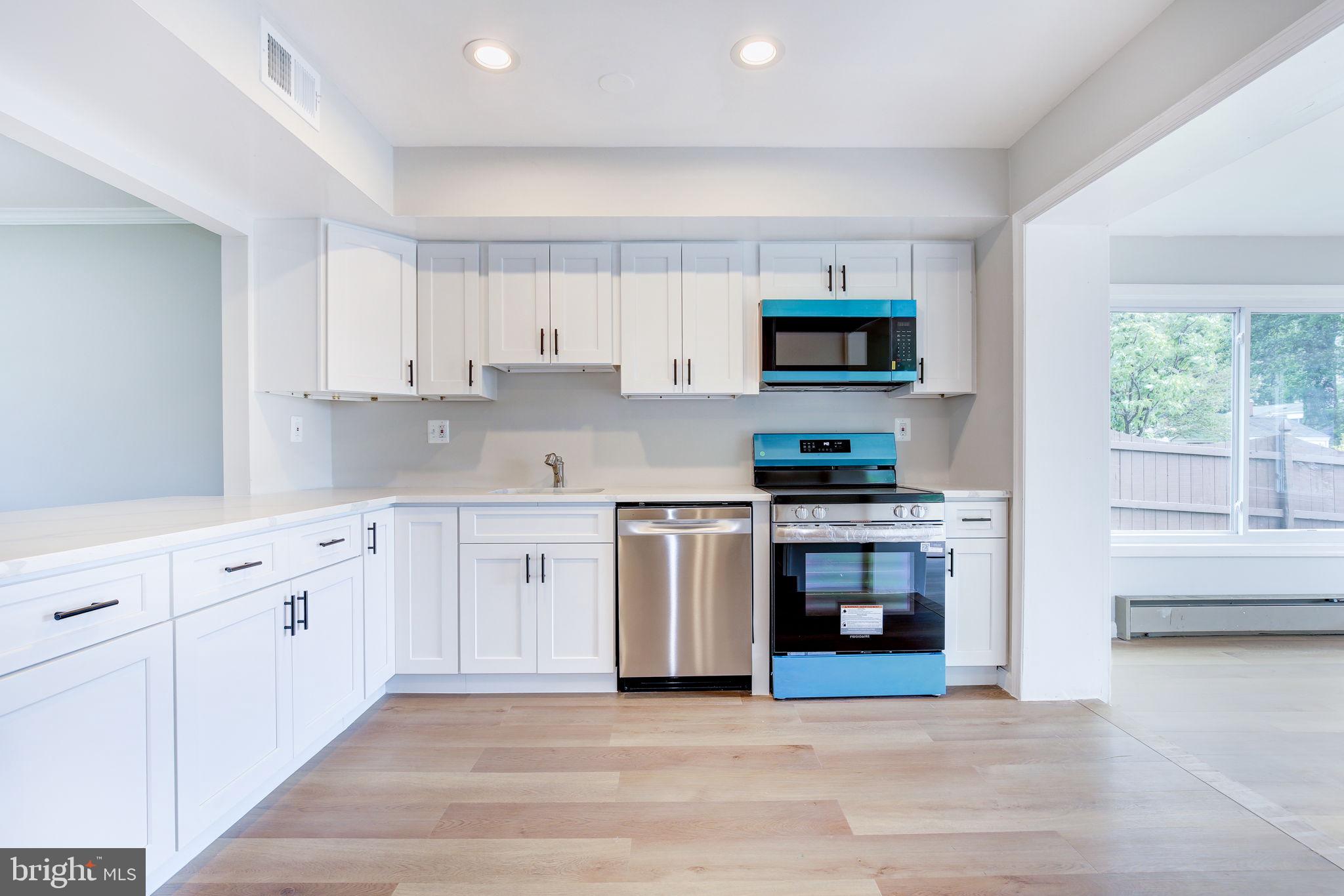 11830 Charles Road Silver Spring, MD 20906 - Photo 29 of 54 a kitchen with stainless steel appliances granite countertop a stove a sink and a microwave
