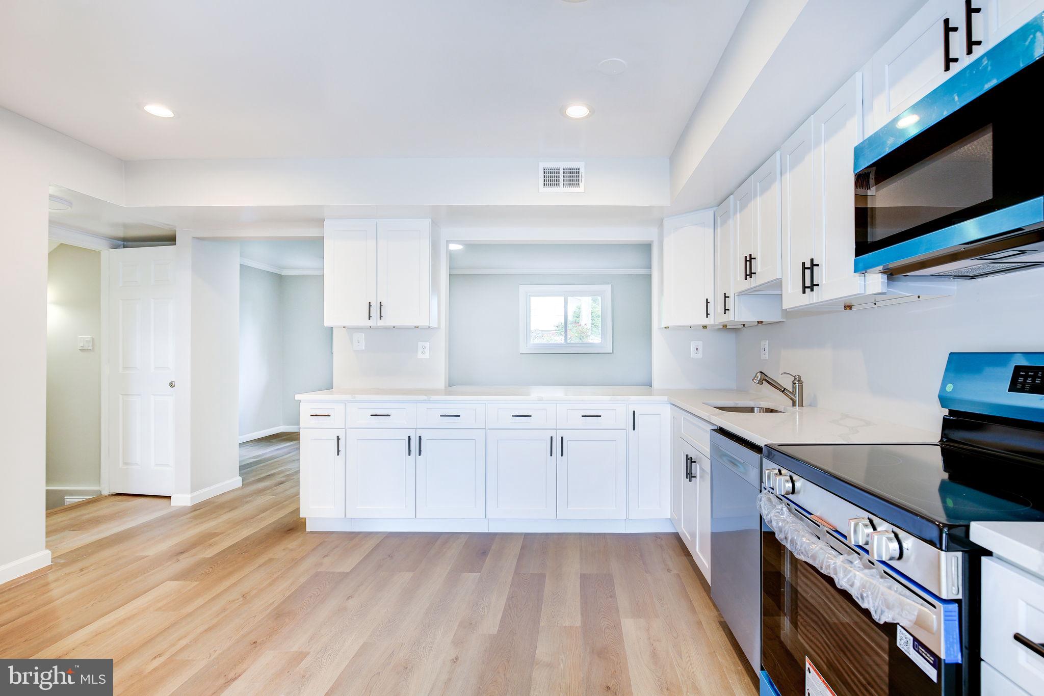 11830 Charles Road Silver Spring, MD 20906 - Photo 30 of 54 a kitchen with stainless steel appliances white cabinets a sink and a stove