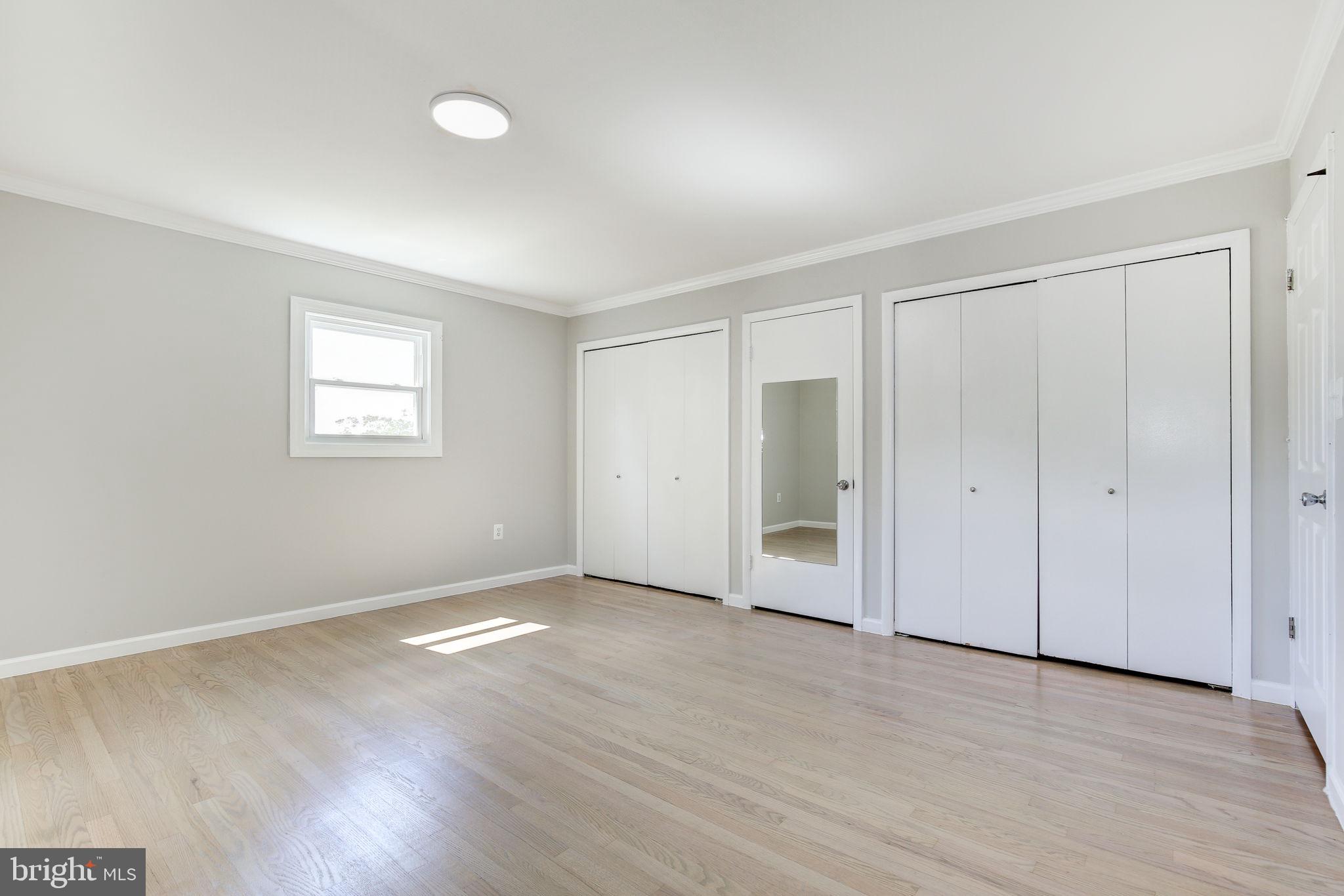 11830 Charles Road Silver Spring, MD 20906 - Photo 9 of 54 an empty room with wooden floor and windows