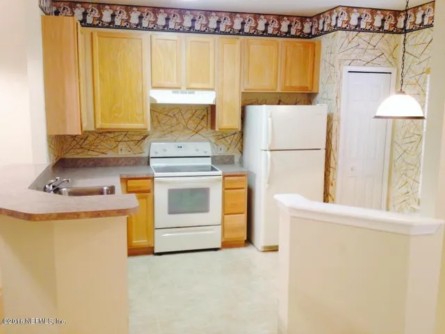 a kitchen with a stove a sink and a refrigerator