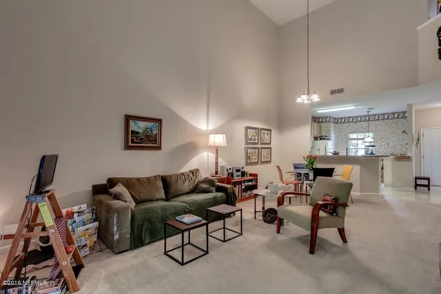 a living room with furniture a dining table and a window