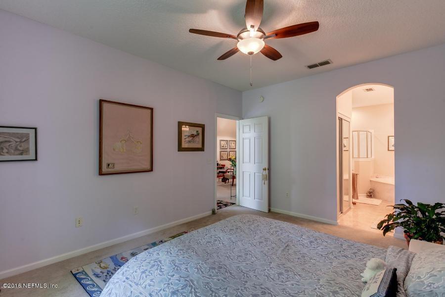 1816 Cross Pines Drive Fleming Island, FL 32003 - Photo 8 of 13 a bedroom with a bed and a chandelier