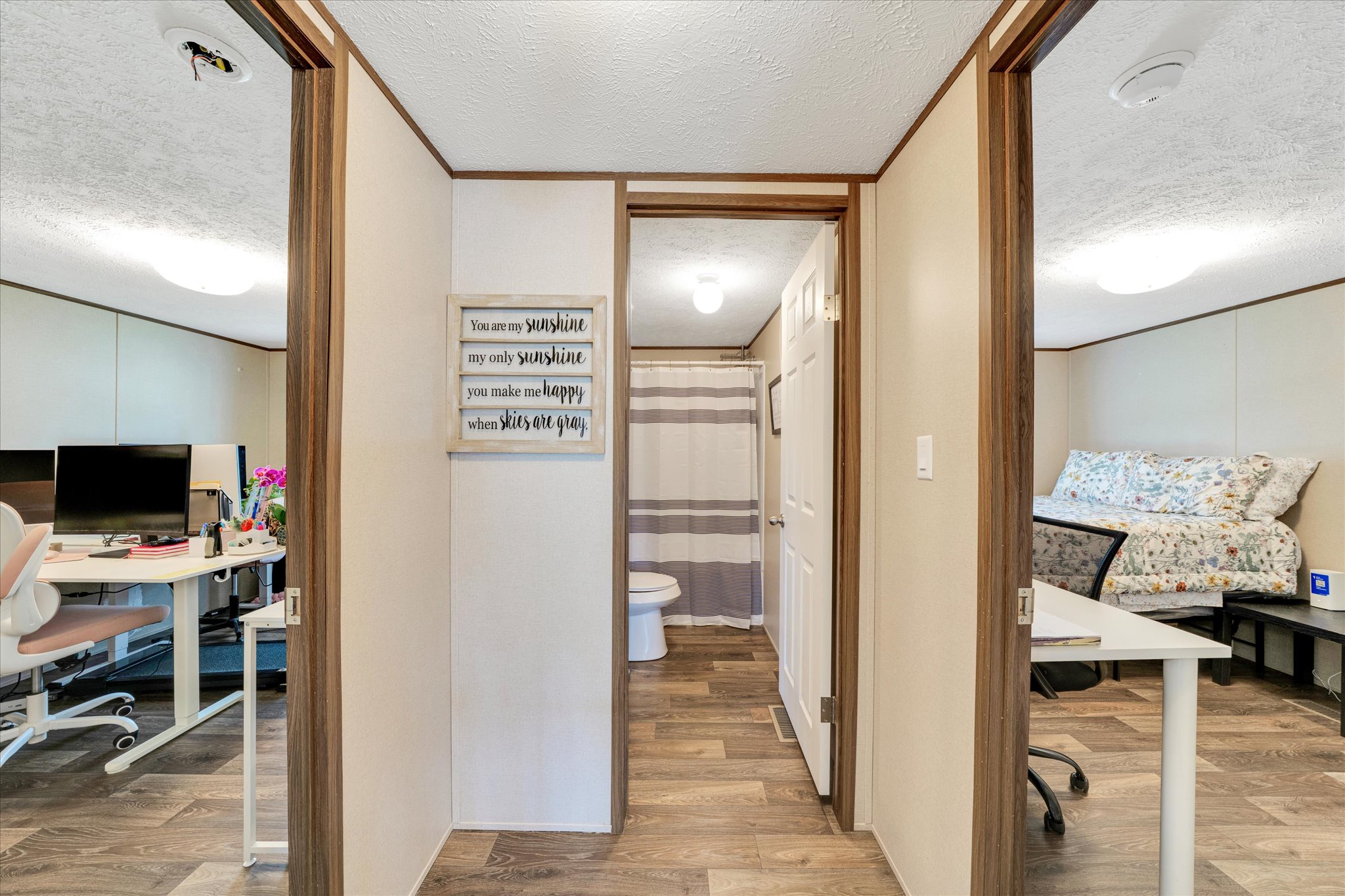 2755 Washburn Road Luling, TX 78648 - Photo 18 of 40 Hardwood-style flooring extends through the hallway, connecting diverse living spaces.