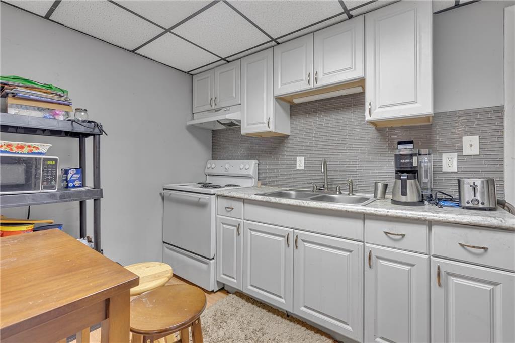 565 East Madison Street Rochester, PA 15074 - Photo 3 of 13 a kitchen with granite countertop white cabinets and white appliances