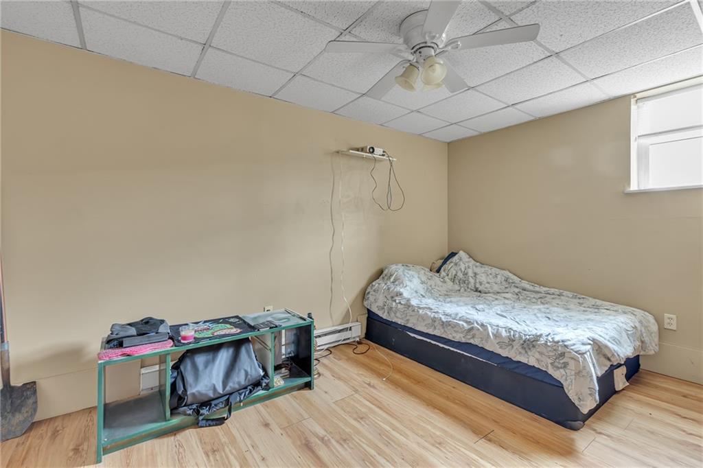 565 East Madison Street Rochester, PA 15074 - Photo 9 of 13 a bedroom with a bed and a wooden floor