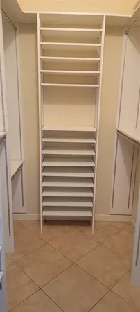 a view of walk in closet with empty racks