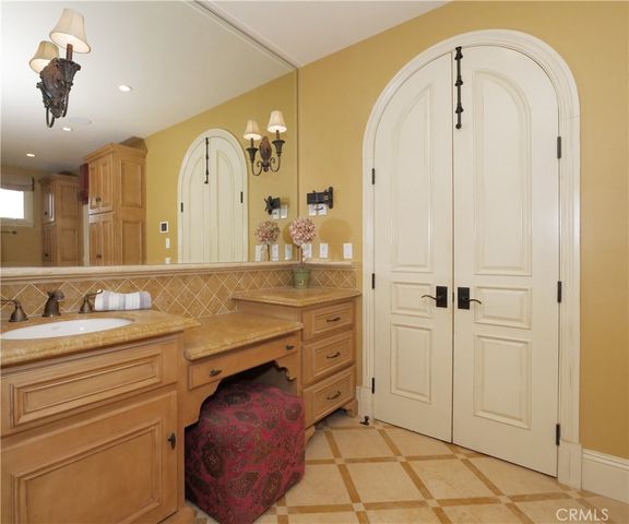 a bathroom with a granite countertop sink a mirror and a bathtub