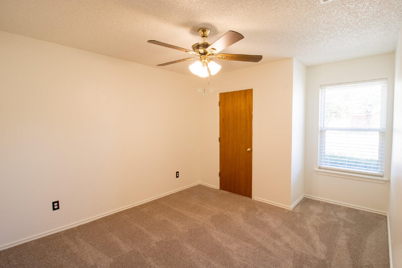 5731 95th Street Lubbock, TX 79424 - Photo 27 of 30 a view of a room with a ceiling fan and a window