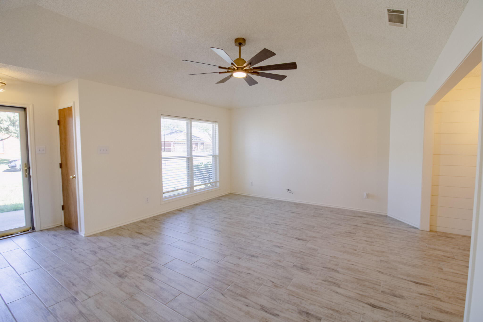 5731 95th Street Lubbock, TX 79424 - Photo 3 of 30 a view of empty room with wooden floor and fan