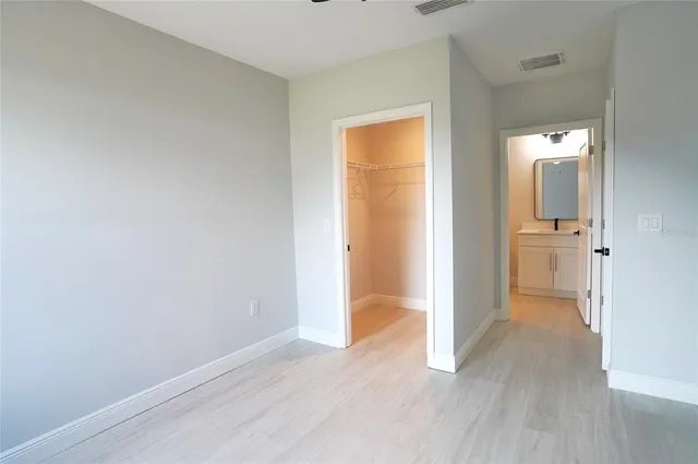 an empty room with wooden floor and a bathroom