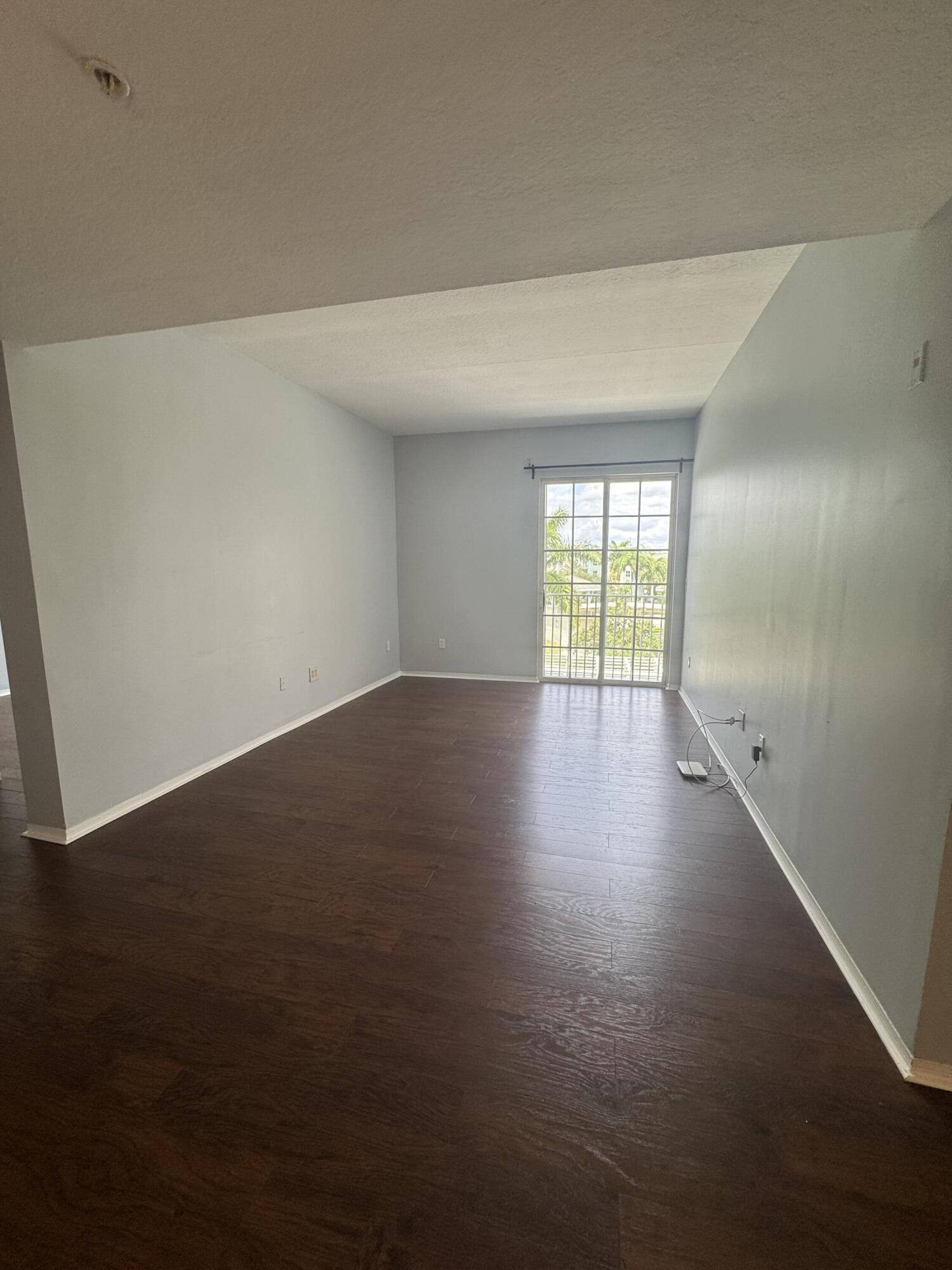 1200 Town Center Drive, Unit 426 Jupiter, FL 33458 - Photo 3 of 11 an empty room with wooden floor and windows
