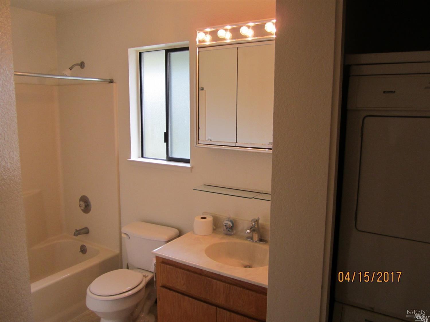 1939 Windmill Circle Santa Rosa, CA 95403 - Photo 13 of 20 a bathroom with a granite countertop sink a toilet and shower