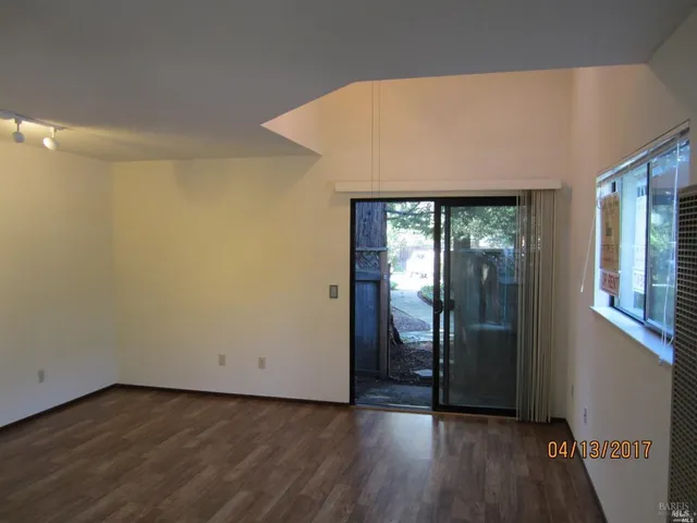 a view of a hallway with wooden floor and a window