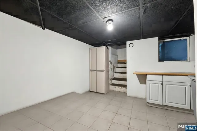 a view of a refrigerator in kitchen and an empty room