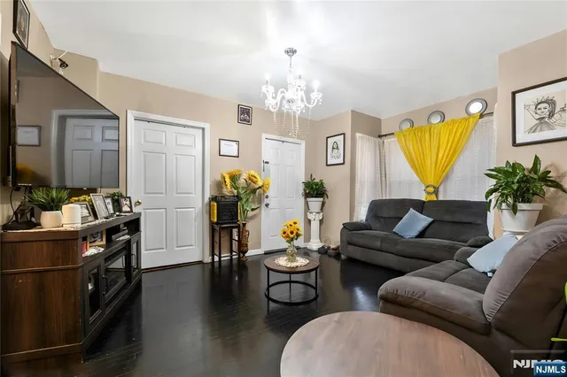 a living room with furniture a chandelier and a dining table