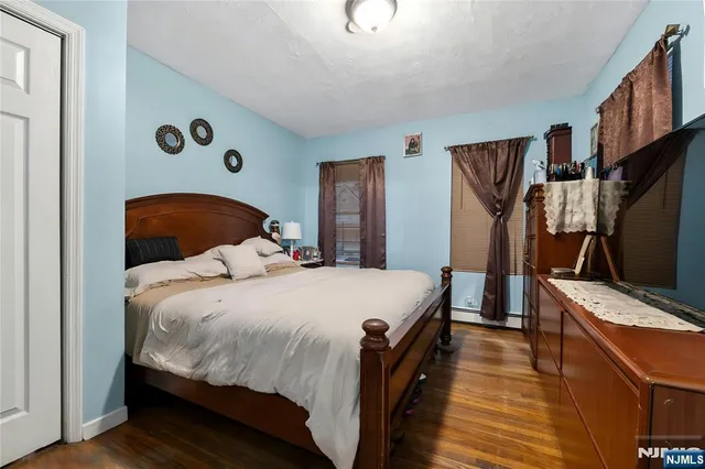 a bedroom with a bed and a flat tv screen on the dresser