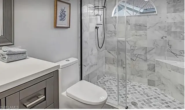 a white toilet sitting next to a shower