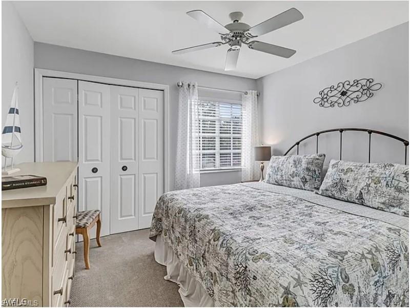 13060 Amberley Court, Unit 807 Bonita Springs, FL 34135 - Photo 15 of 33 a bedroom with a large bed and a chandelier