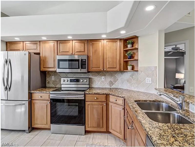13060 Amberley Court, Unit 807 Bonita Springs, FL 34135 - Photo 2 of 33 a kitchen with granite countertop a sink and steel stainless steel appliances