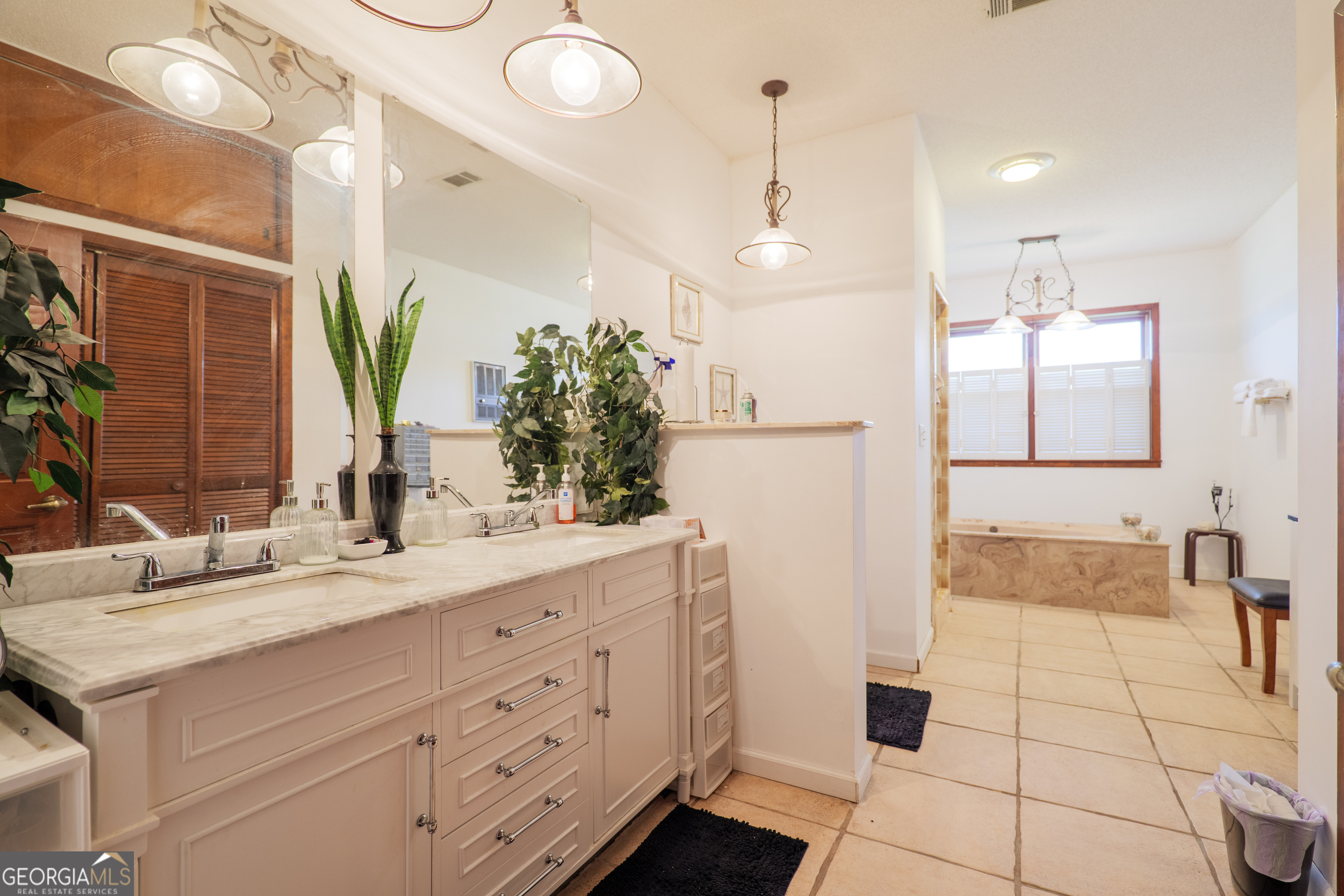 3473 Kay Circle Valdosta, GA 31606 - Photo 40 of 79 a bathroom with a double vanity sink a large mirror and shower