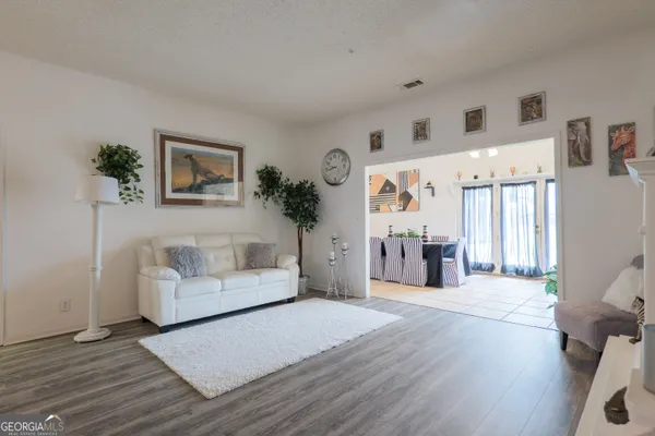 a kitchen with stainless steel appliances kitchen island granite countertop a table chairs sink and cabinets