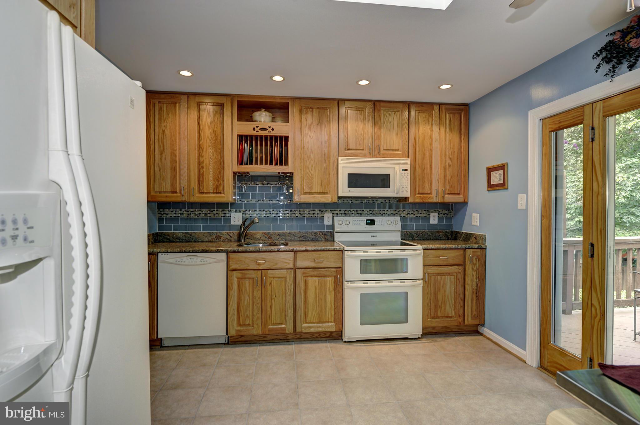 8609 Woodview Drive Springfield, VA 22153 - Photo 13 of 28 a kitchen with stainless steel appliances granite countertop a stove a sink and a refrigerator