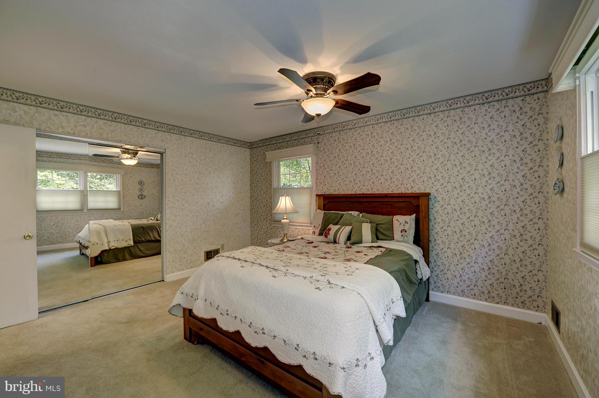 8609 Woodview Drive Springfield, VA 22153 - Photo 17 of 28 a spacious bedroom with a bed and a large mirror