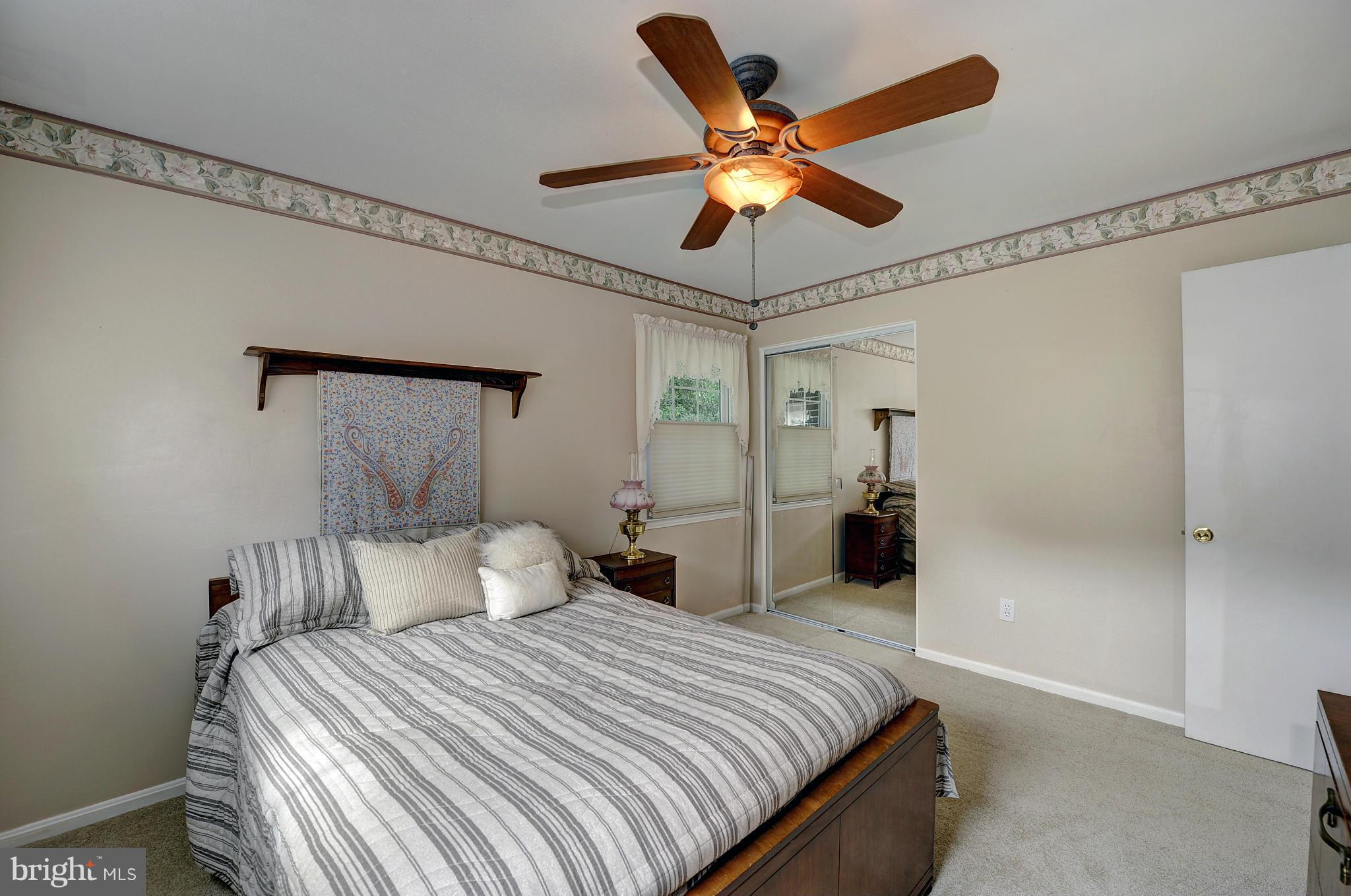 8609 Woodview Drive Springfield, VA 22153 - Photo 20 of 28 a bedroom with a large bed and a chandelier