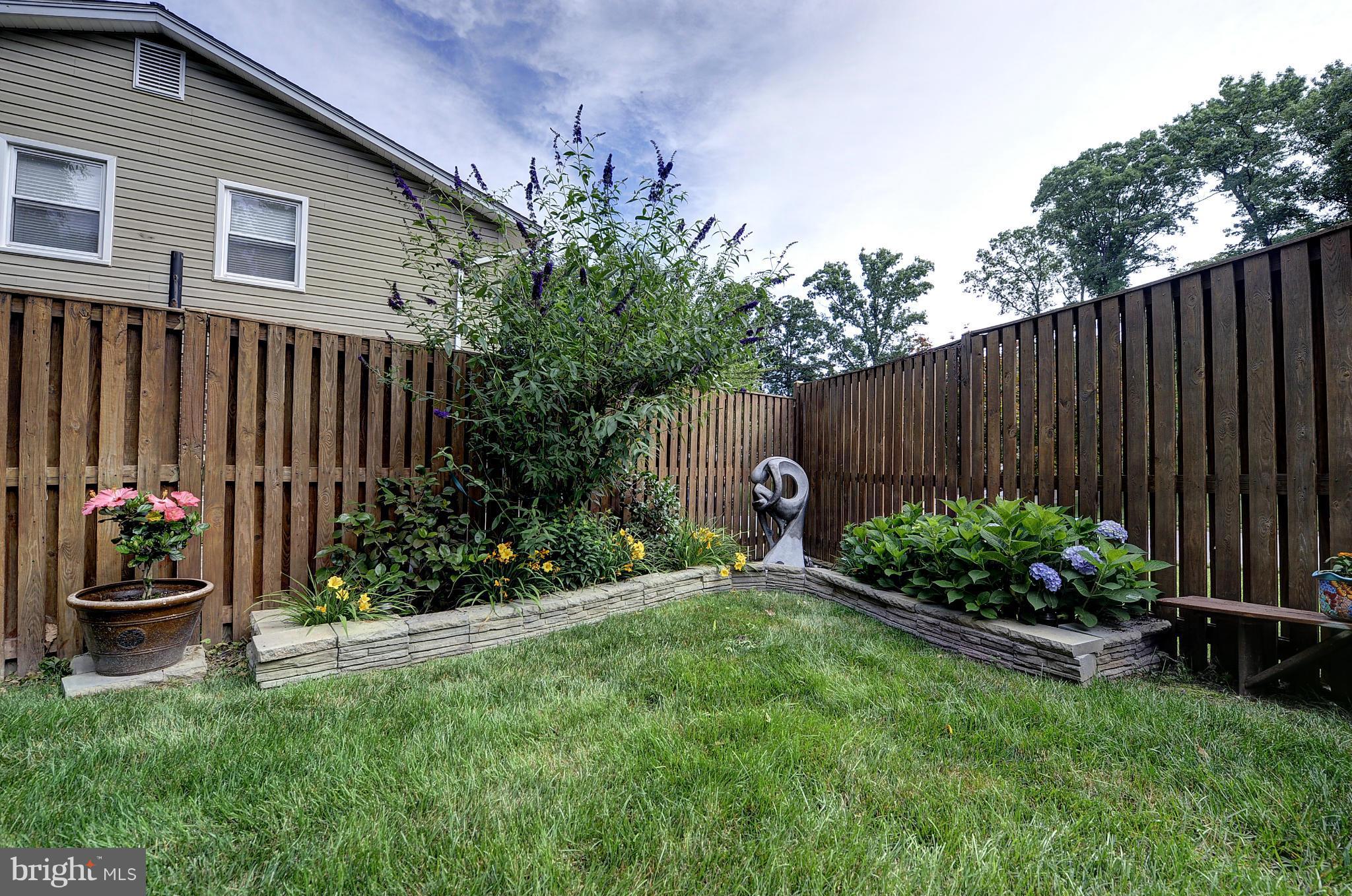 8609 Woodview Drive Springfield, VA 22153 - Photo 4 of 28 a garden with flowers and wooden fence