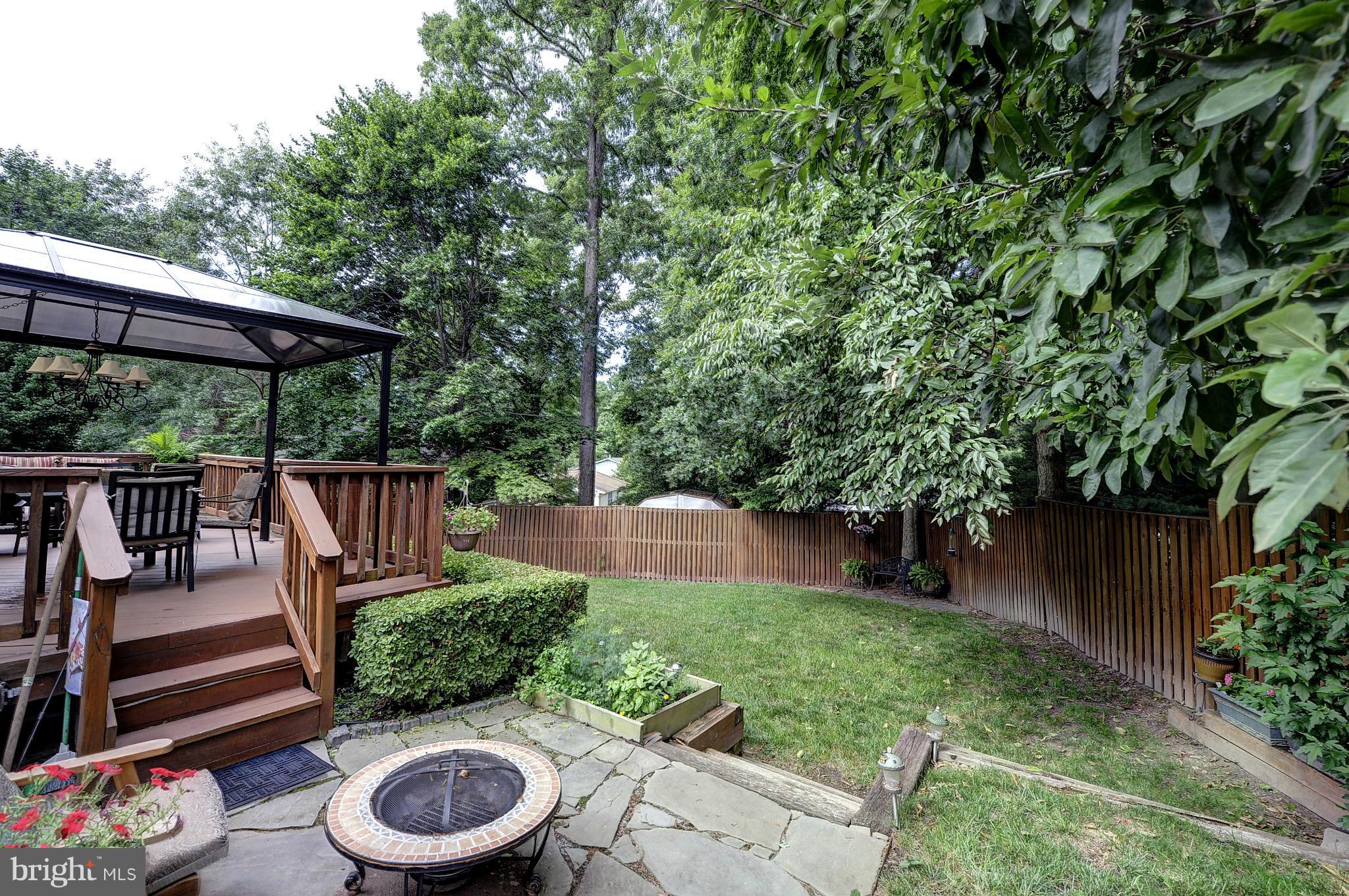8609 Woodview Drive Springfield, VA 22153 - Photo 5 of 28 a view of a chair and tables under an umbrella in backyard