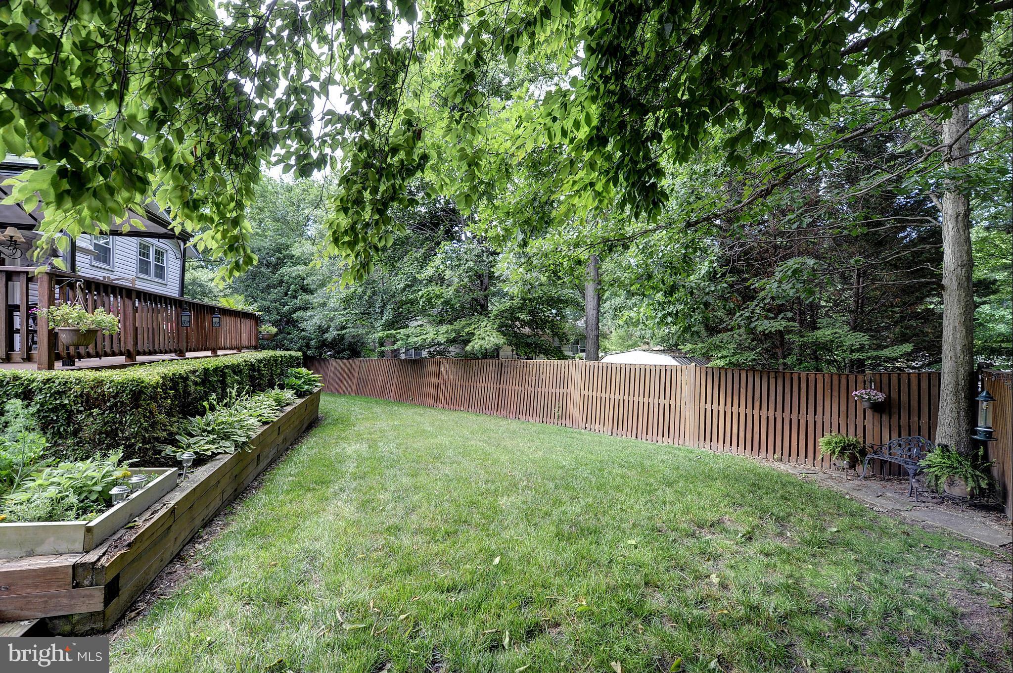 8609 Woodview Drive Springfield, VA 22153 - Photo 6 of 28 a backyard of a house with lots of green space and lake view