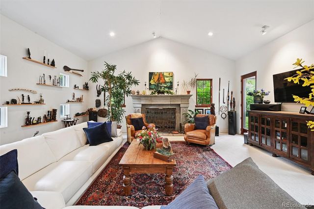a living room with furniture fireplace and a large window