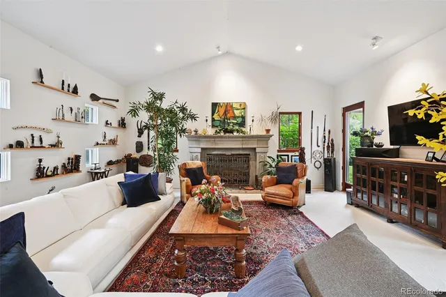 a living room with furniture fireplace and a large window