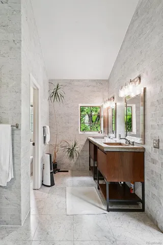 a bathroom with a granite countertop sink and a window