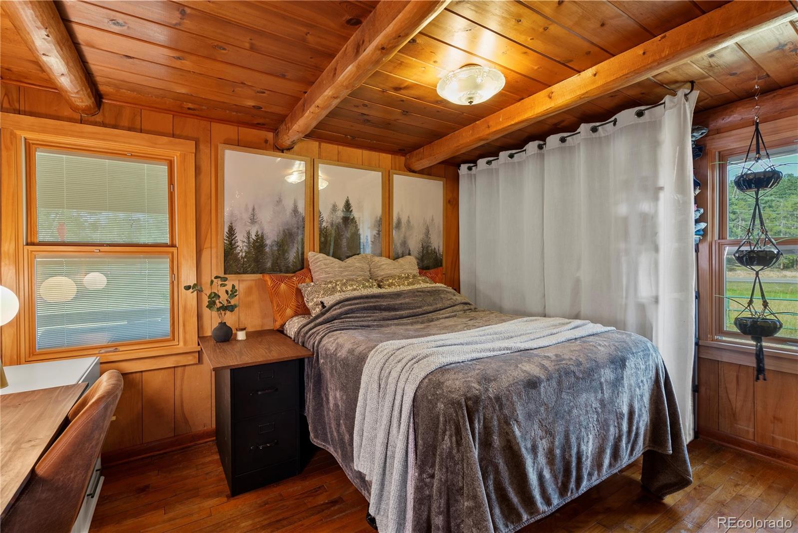 21852 Pleasant Park Road Conifer, CO 80433 - Photo 18 of 47 a bed sitting in a bedroom next to a window